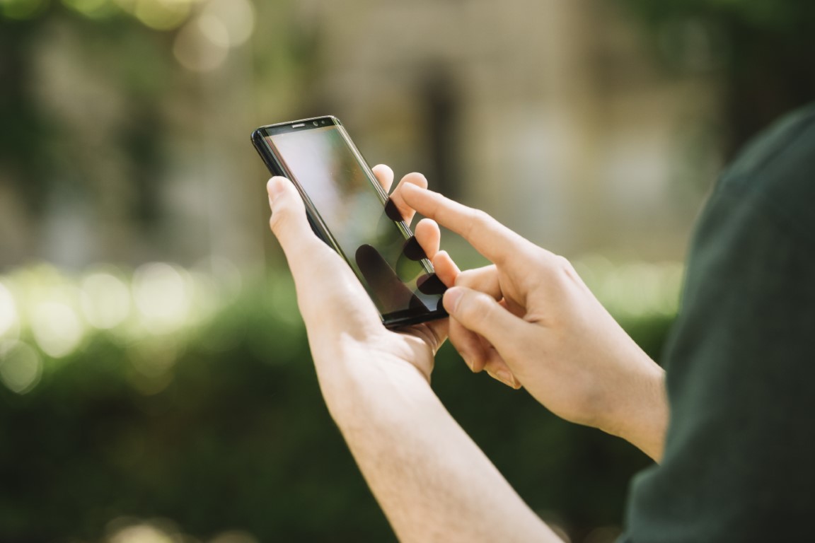 mãos de mulher segurando celular - controlenamao