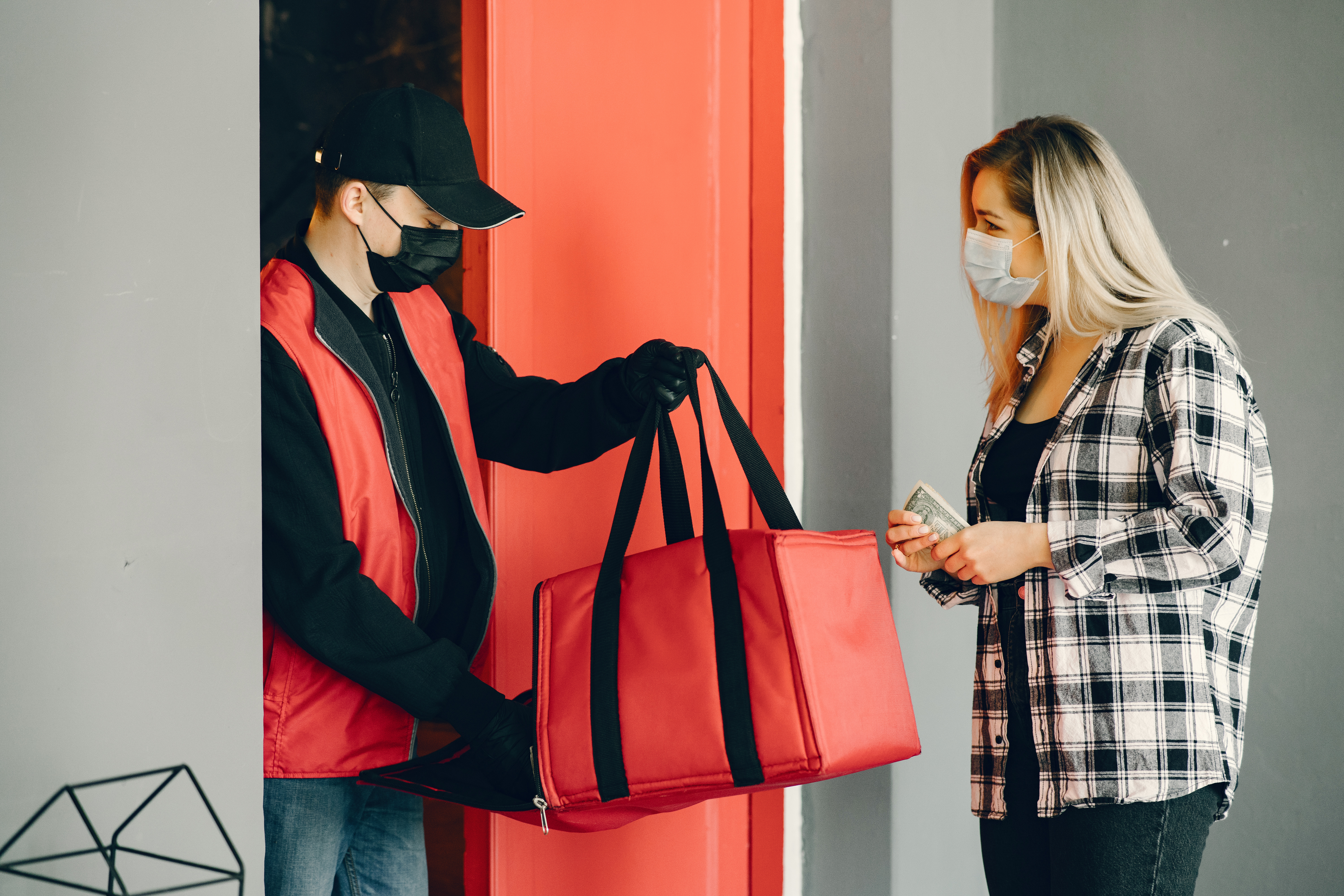 entregador com bolsa de delivery entregando para mulher