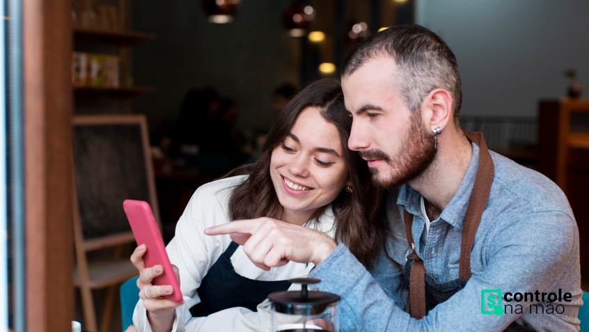 homem e mulher em cafeteria vendo celular | sistema para restaurantes controle na mão