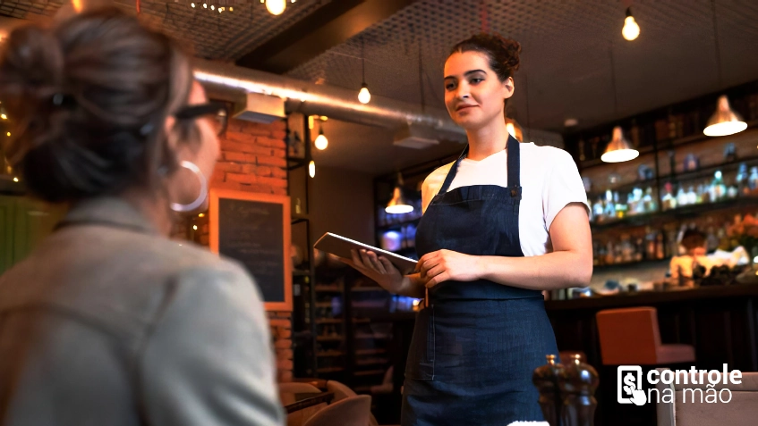 mulher fazendo pedido para garçonete com tablet na mão. sistema para restaurantes controlenamão.