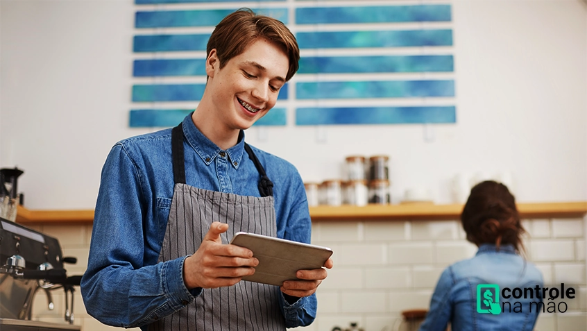 Homem jovem anotando pedidos em tablet em restaurante - sistema para restaurantes ControleNaMão