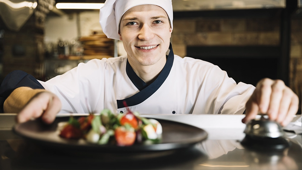 cozinheiro colocando o pedido em um balcão e apertando a campainha