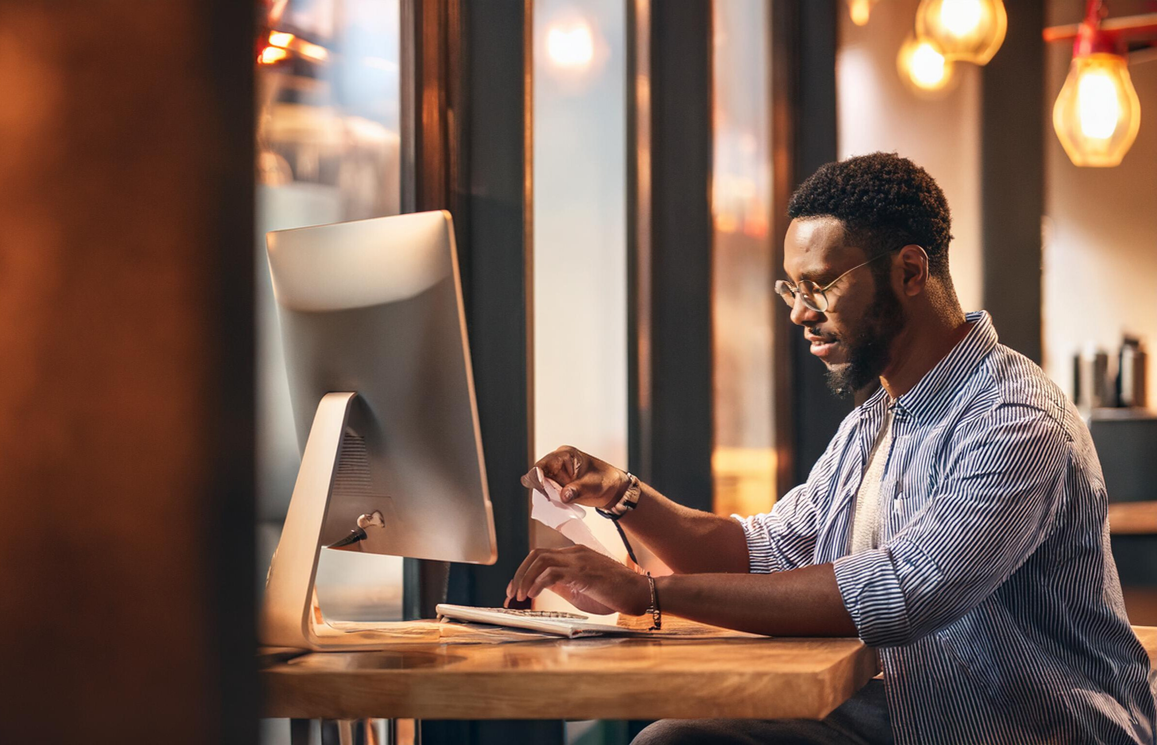 homem utilizando computador no restaurante, imprimindo nota fiscal