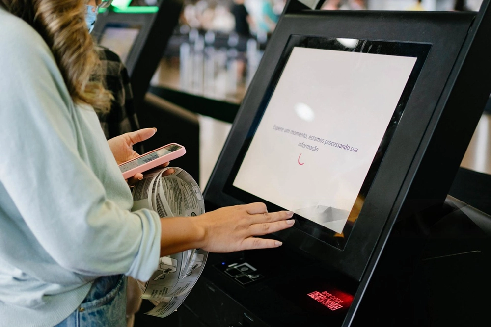 mulher em frente a um totem de autoatendimento fazendo seu pedido