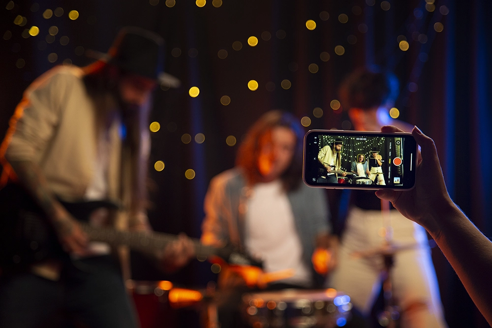 artistas em um palco arrumando seus instrumentos com uma pessoa tirando sua fotografia