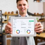 Dono de restaurante sorrindo e segurando tablet com dashboard do ControleNaMão mostrando número de vendas, faturamento e ticket médio