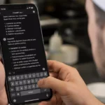 Cozinheiro de touca branca segura o celular mostrando uma conversa no ChatGPT com dicas para aumentar vendas, fidelizar clientes e reduzir desperdício do restaurante.