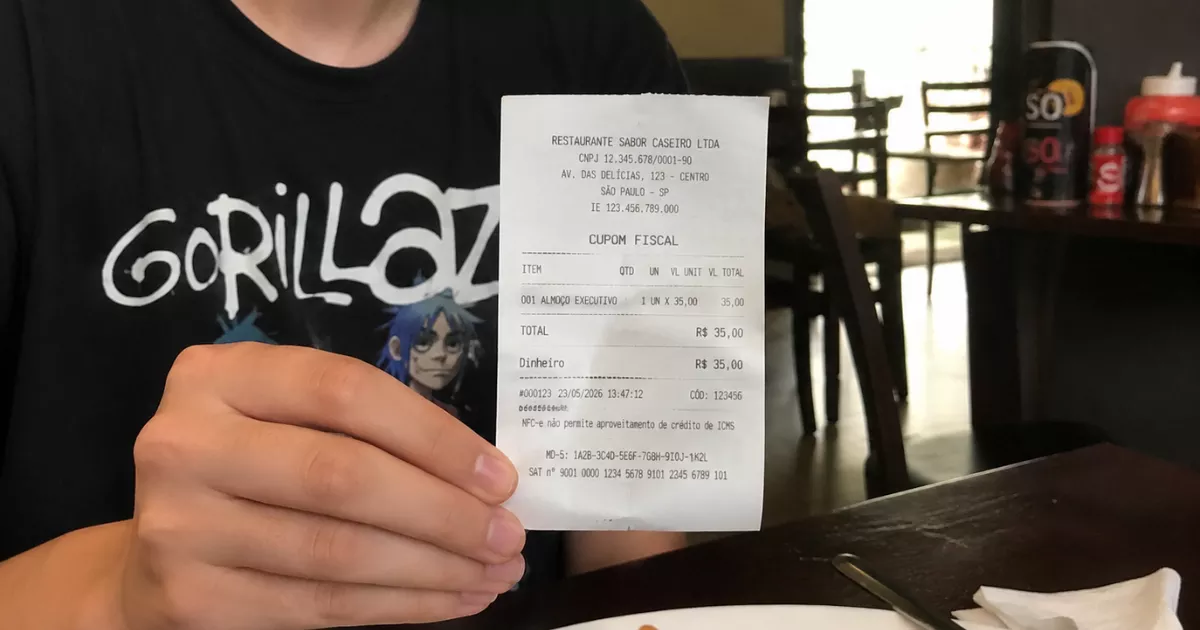 Cliente sentado à mesa de restaurante segurando cupom fiscal de almoço executivo no valor de R$ 35, com pratos e copos ao fundo