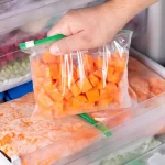 Alimentos congelados organizados em sacos identificados dentro de freezer de restaurante