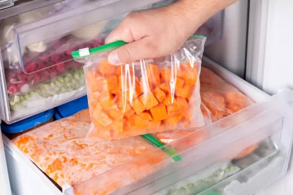 Alimentos congelados organizados em sacos identificados dentro de freezer de restaurante
