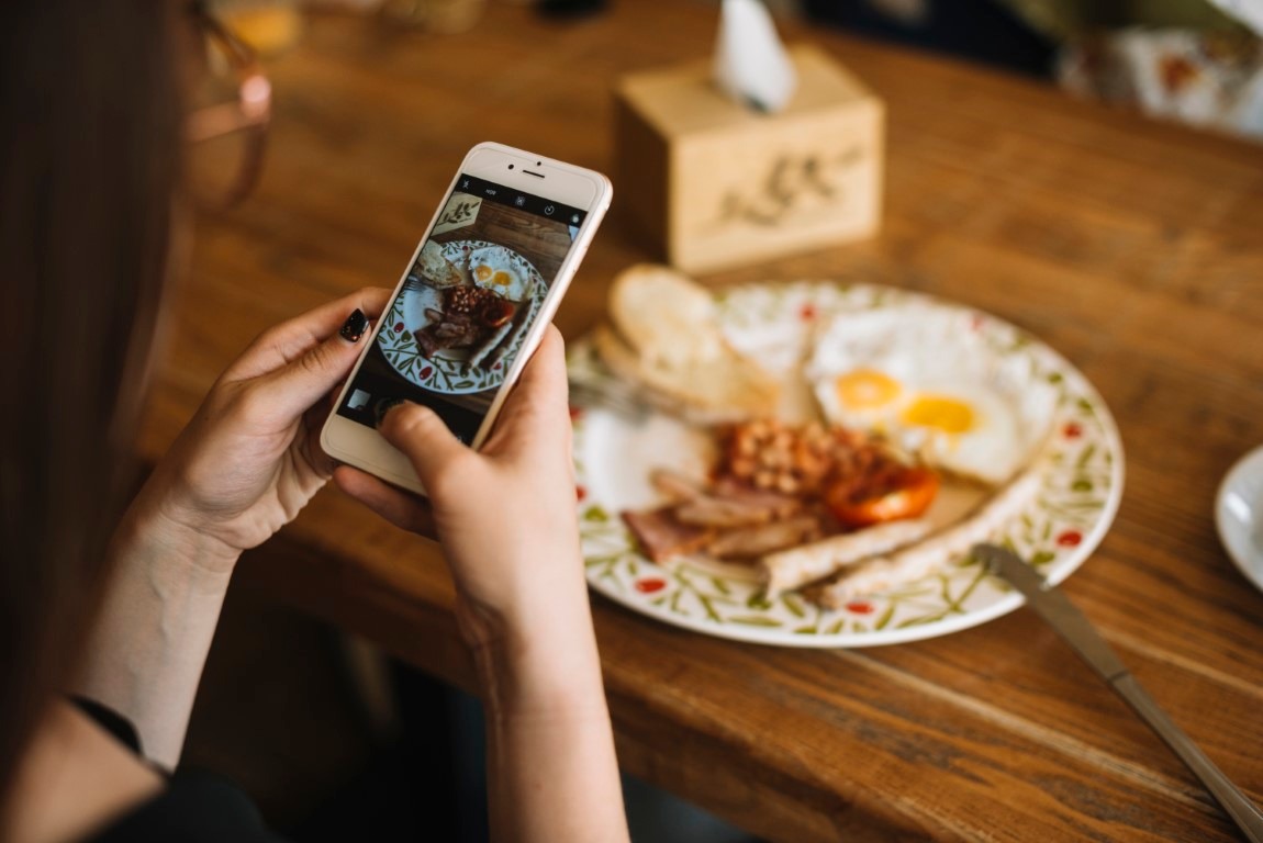 cliente tirando foto do prato no restaurante para postar nas redes sociais - controlenamao