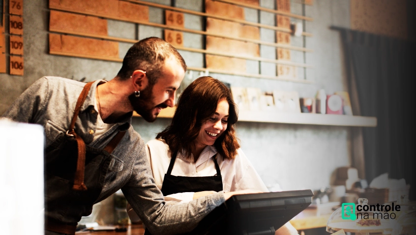 homem e mulher usando computador em restaurante - controle na mao