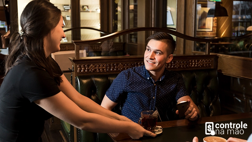 mulher servindo caneca de café para cliente em mesa de restaurante - sistema controle na mão