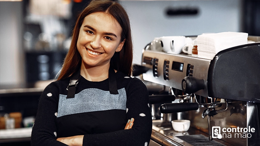 mulher sorrindo em frente a cafeteira - sistema para restaurantes controle na mão