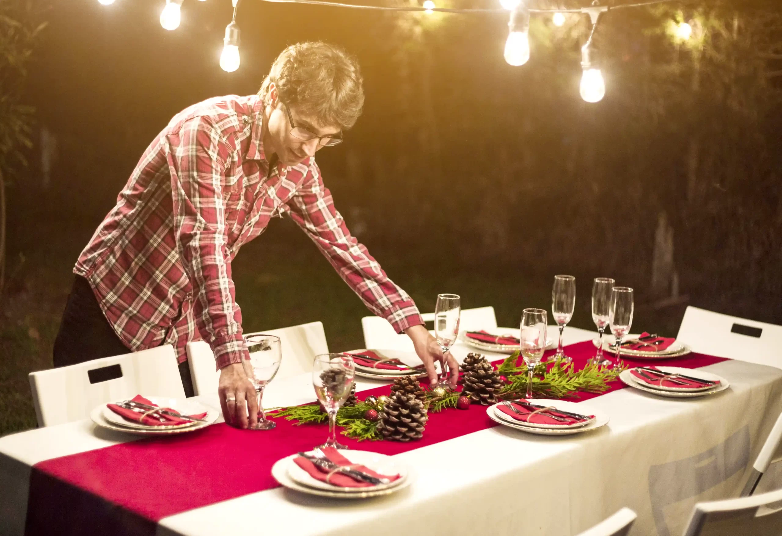 Dono de restaurante preparando uma mesa para uma celebração especial, com pratos festivos e temáticos