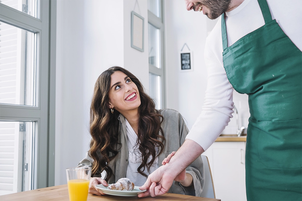 garçon servindo cliente com croissant