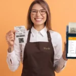 Operadora de avental marrom segurando cupom fiscal NFC-e impresso em uma mão e maquininha com o menu do ControleNaMão na outra, fundo laranja