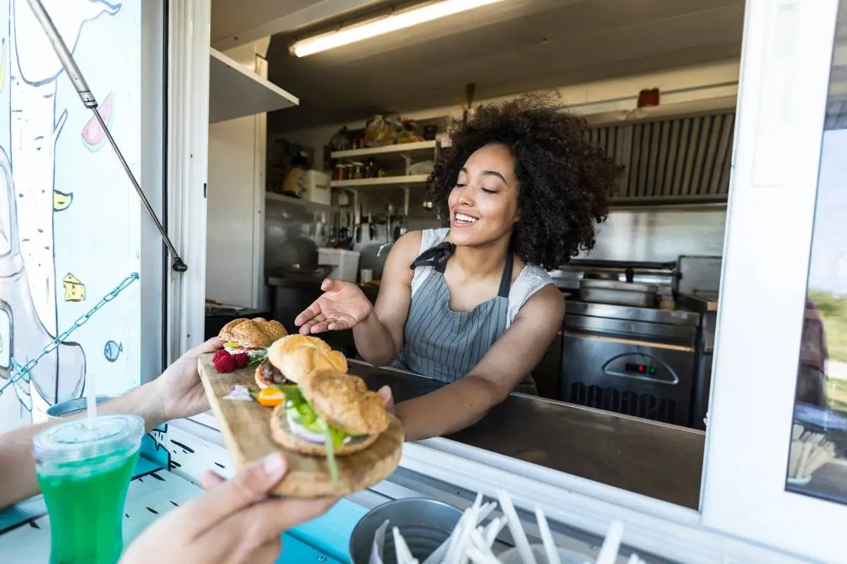 Food truck estilizado com decoração colorida e assentos externos, mostrando o ambiente atrativo e descontraído oferecido por esses negócios móveis.