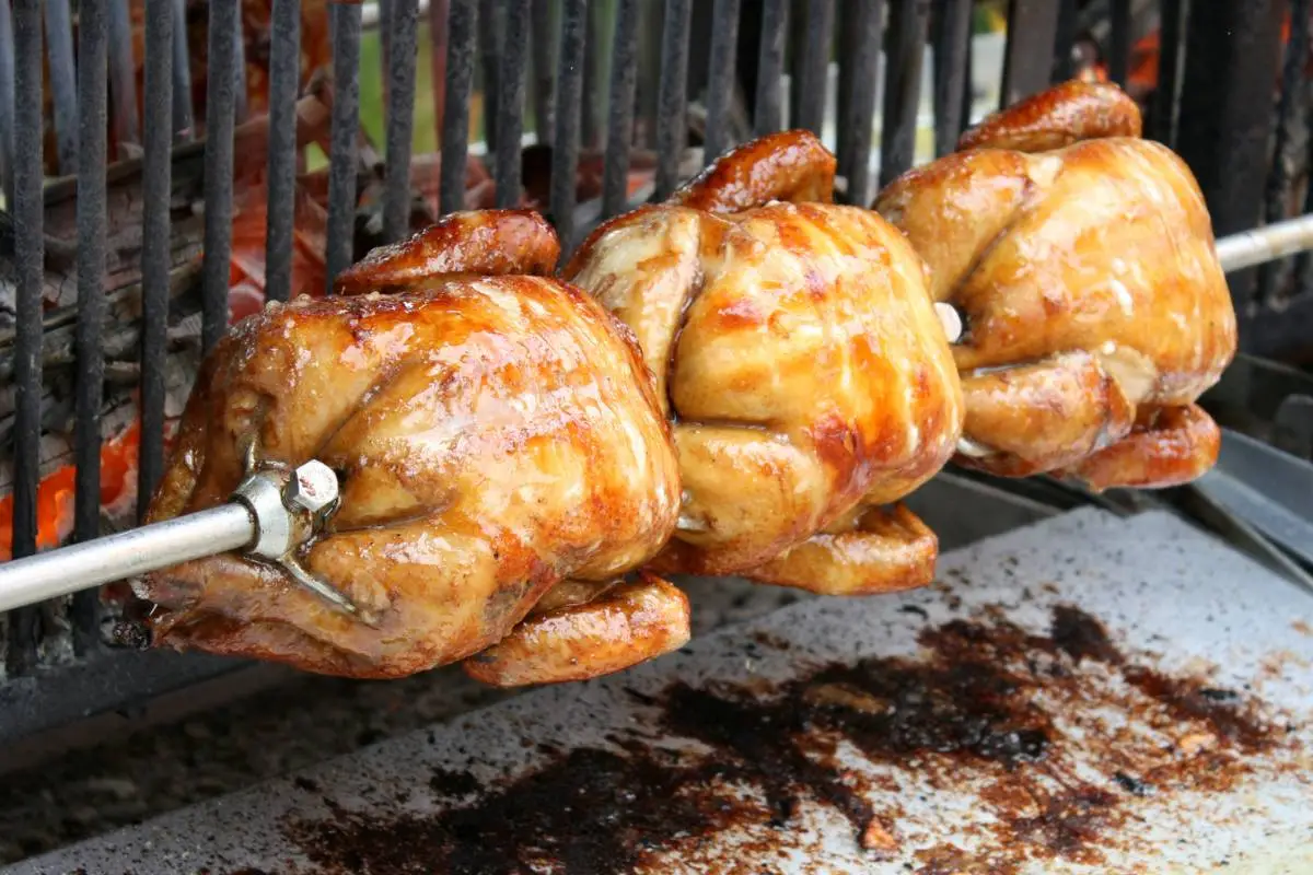 Frango assado girando no espeto em churrasqueira de restaurante