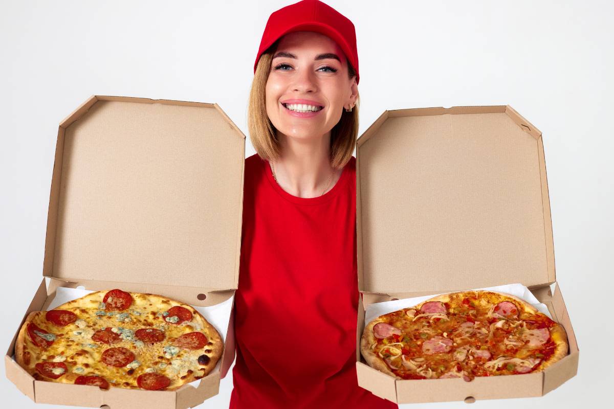  Entregadora de pizzaria segurando duas caixas de pizza abertas, sorrindo. Representa o serviço de entrega eficiente e o atendimento ao cliente em pizzarias.