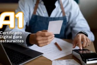 Atendente de camisa azul-clara e avental jeans segura um comprovante impresso e digita na maquininha, ao lado de notebook e papéis, com o texto A1 Certificado Digital para Restaurantes