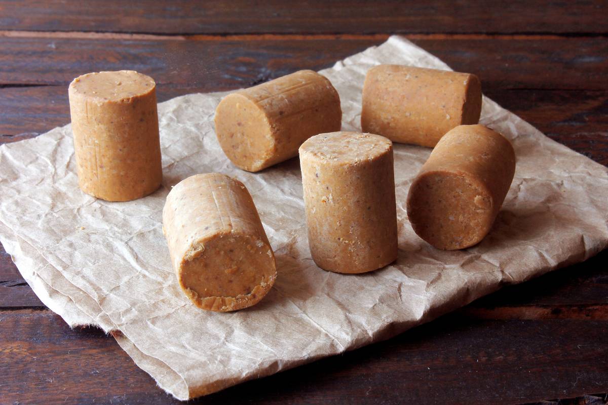 Paçoquinha low carb: Doces individuais de paçoca preparados com amendoim torrado e adoçantes naturais, dispostos sobre papel pardo.