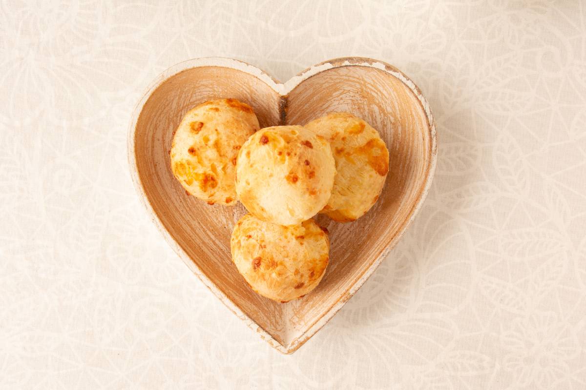Pão de queijo low carb: Pães de queijo low carb dispostos em um prato em formato de coração, com textura dourada e macia.