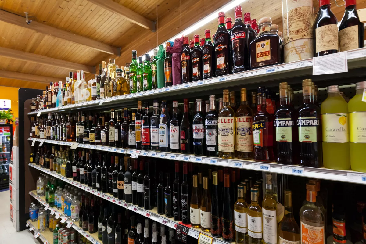 Prateleiras cheias de garrafas de bebidas alcoólicas, como vinhos, destilados e licores, organizadas em um ambiente de distribuidora. A imagem mostra variedade de produtos e reforça a ideia de negócios que atuam com volume e diversidade no setor de bebidas.
