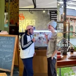 Montagem com três cafeterias: mulher sorridente ao lado de quadro negro na Mary Ann Apple Factory, dois clientes no balcão do Supernova Coffee, e cliente apreciando café na janela envidraçada do Tudo Café e Drinks com cookies e prensa francesa na mesa.