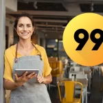 Restauradora sorridente com tablet na mão e integração ativa com a 99Food para aumentar vendas no delivery.