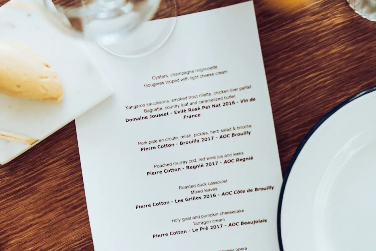 Cardápio minimalista com pratos e harmonização de vinhos impresso em papel refinado, ideal para restaurantes gourmet e autorais.