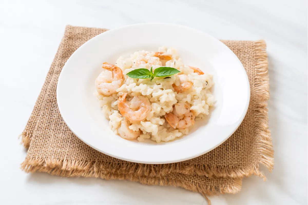 Risoto de camarão cremoso com manjericão, uma opção sofisticada e saborosa de comida de primavera para restaurante.