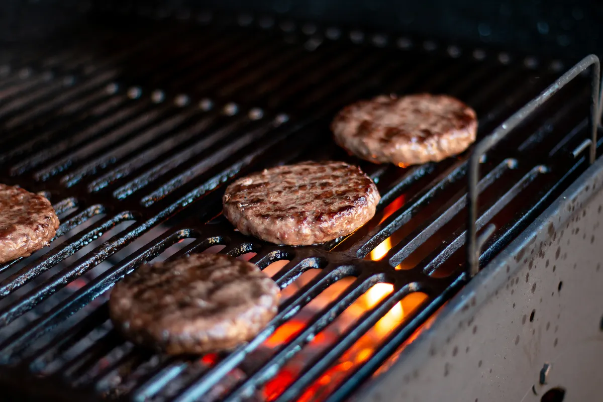 Hambúrgueres grelhados diretamente sobre a Char Broiler, com chamas. A grelha confere o sabor defumado ideal para hamburguerias gourmet.
