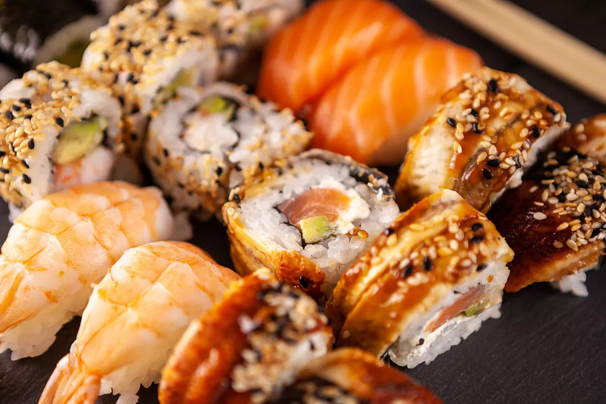 Combinado variado de sushi com diversos tipos de uramakis, niguiris de camarão e rolls, mostrando a diversidade do cardápio. A variedade e o custo dos ingredientes são fatores que influenciam o lucro do restaurante japonês