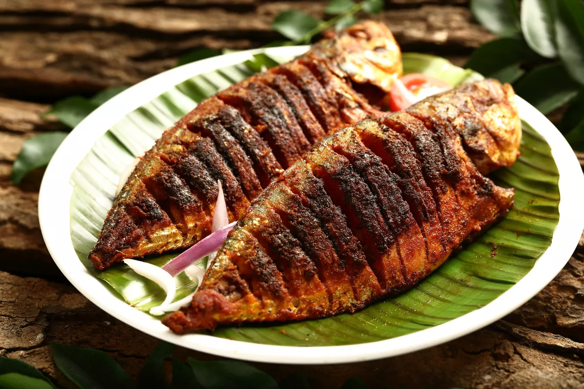 Prato com dois peixes assados servidos sobre folha de bananeira, representando o resultado final da gestão integrada de pesque e pague, desde a pesca até o preparo e venda do peixe ao cliente.