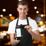 Garçom em ambiente de restaurante segurando uma maquininha Cielo Lio integrada ao sistema PDV do CNM, demonstrando a agilidade do atendimento e pagamento móvel na mesa do cliente