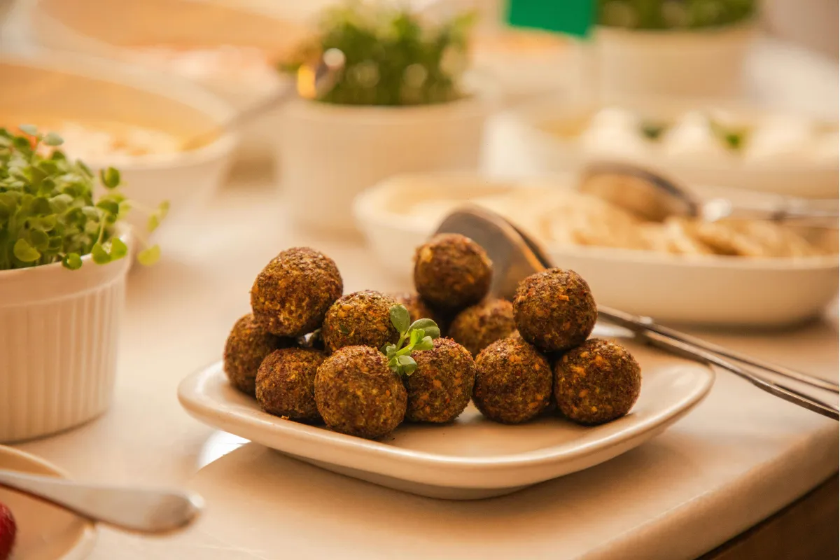 Prato com bolinhos de falafel crocantes, uma opção vegana comum em deliveries de comida árabe.