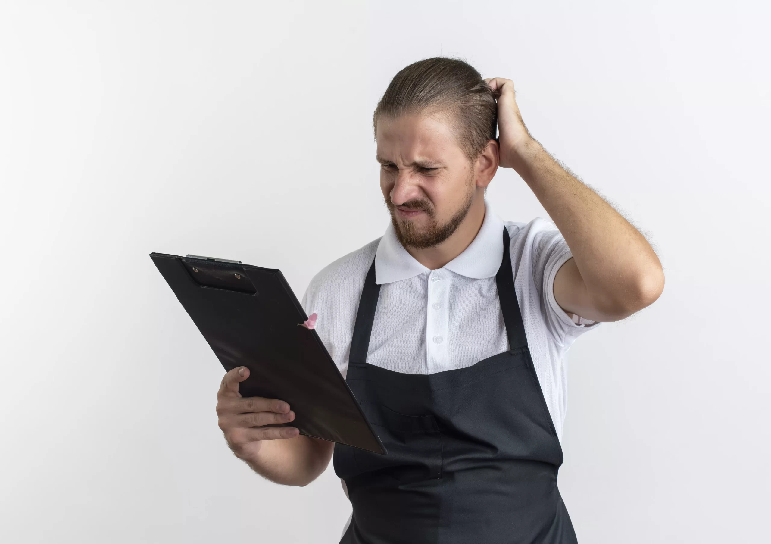 Esta imagem apresenta um homem com avental preto e camisa polo branca, segurando uma prancheta com uma expressão de extrema confusão e frustração. Ele coça a cabeça enquanto olha para os papéis, o que simboliza perfeitamente a dificuldade de lidar com processos manuais e burocráticos.