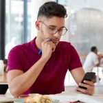 Cliente em restaurante analisando pesquisa de satisfação pelo celular