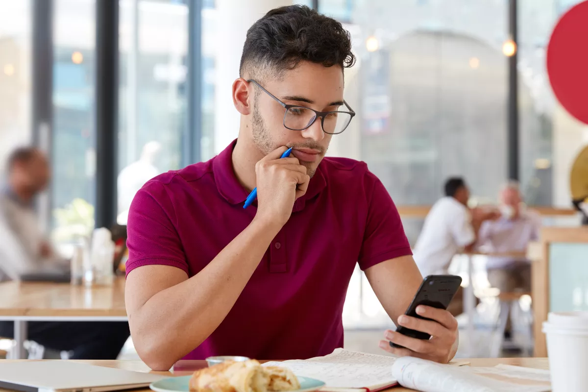 Cliente em restaurante analisando pesquisa de satisfação pelo celular